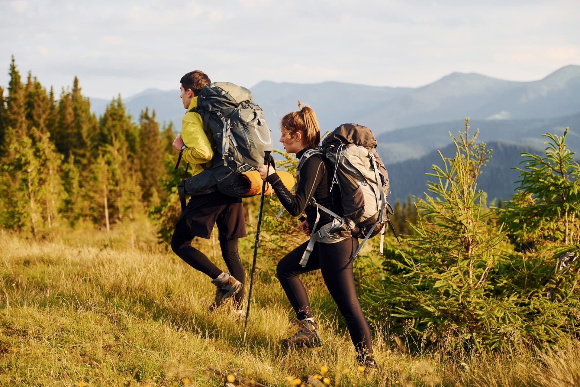 Two people walking together on a hiking trail, enjoying the outdoors.